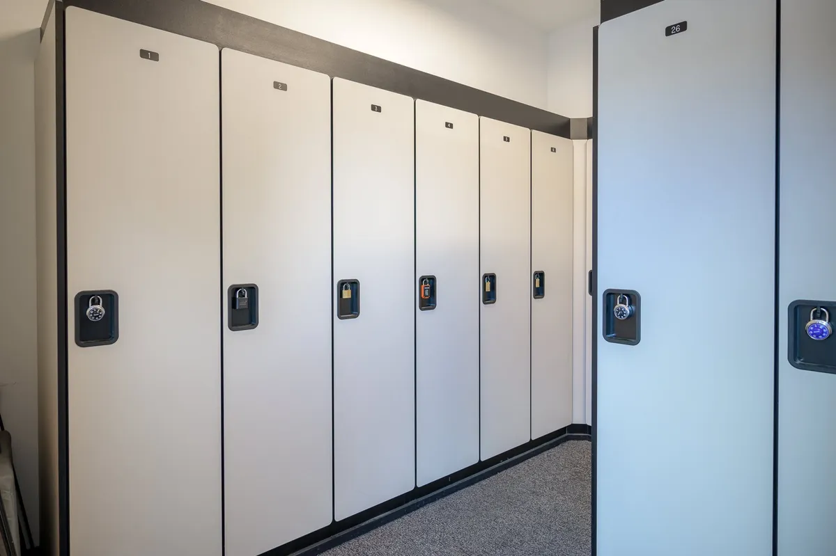 This image shows a row of lockers with padlocks inside a well-lit interior space. The lockers are designed for secure storage, and the setting evokes a sense of preparedness and organization.