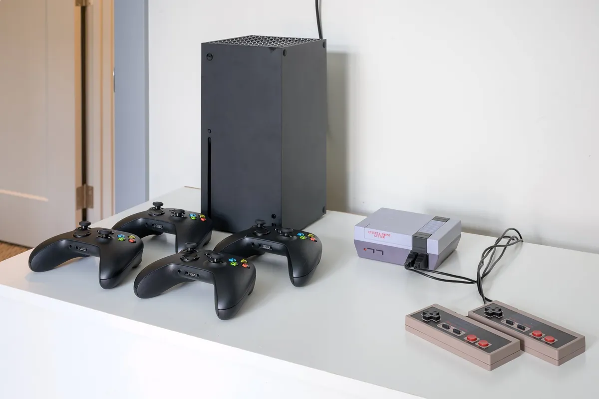 A close-up of a gaming console and controllers laid out on a table, ready for use. The setup hints at a playful atmosphere ideal for socializing and family game nights.